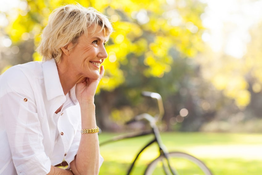 Femme âgée souriante dans un jardin