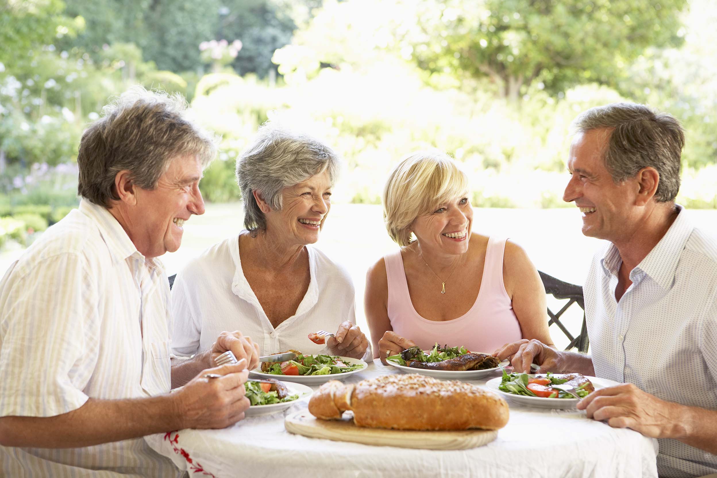 Couples de séniors déjeunant à l'extérieur de la maison